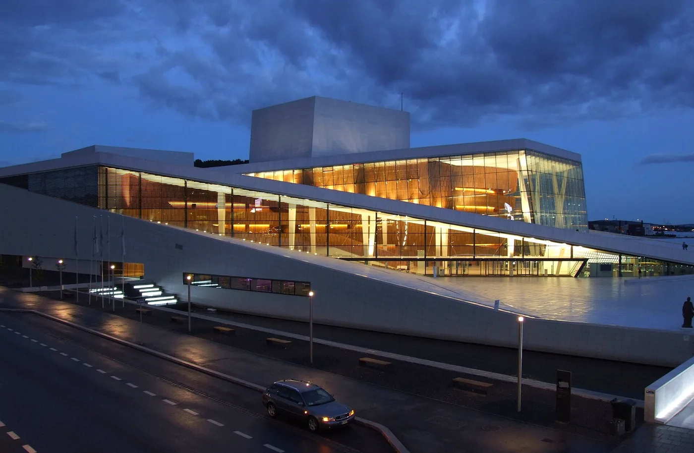 White sloping exterior of the Oslo Opera House beside the harbour