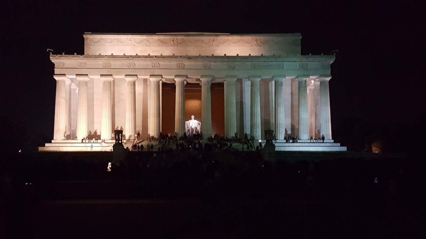 Lincoln Memorial lit at night from the edge of the Reflecting Pool.